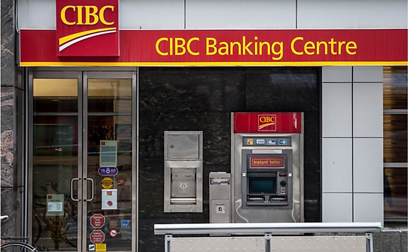 CIBC logo with its ATM, in front of one of their banking center in Toronto. Editorial credit: BalkansCat / Shutterstock.com.