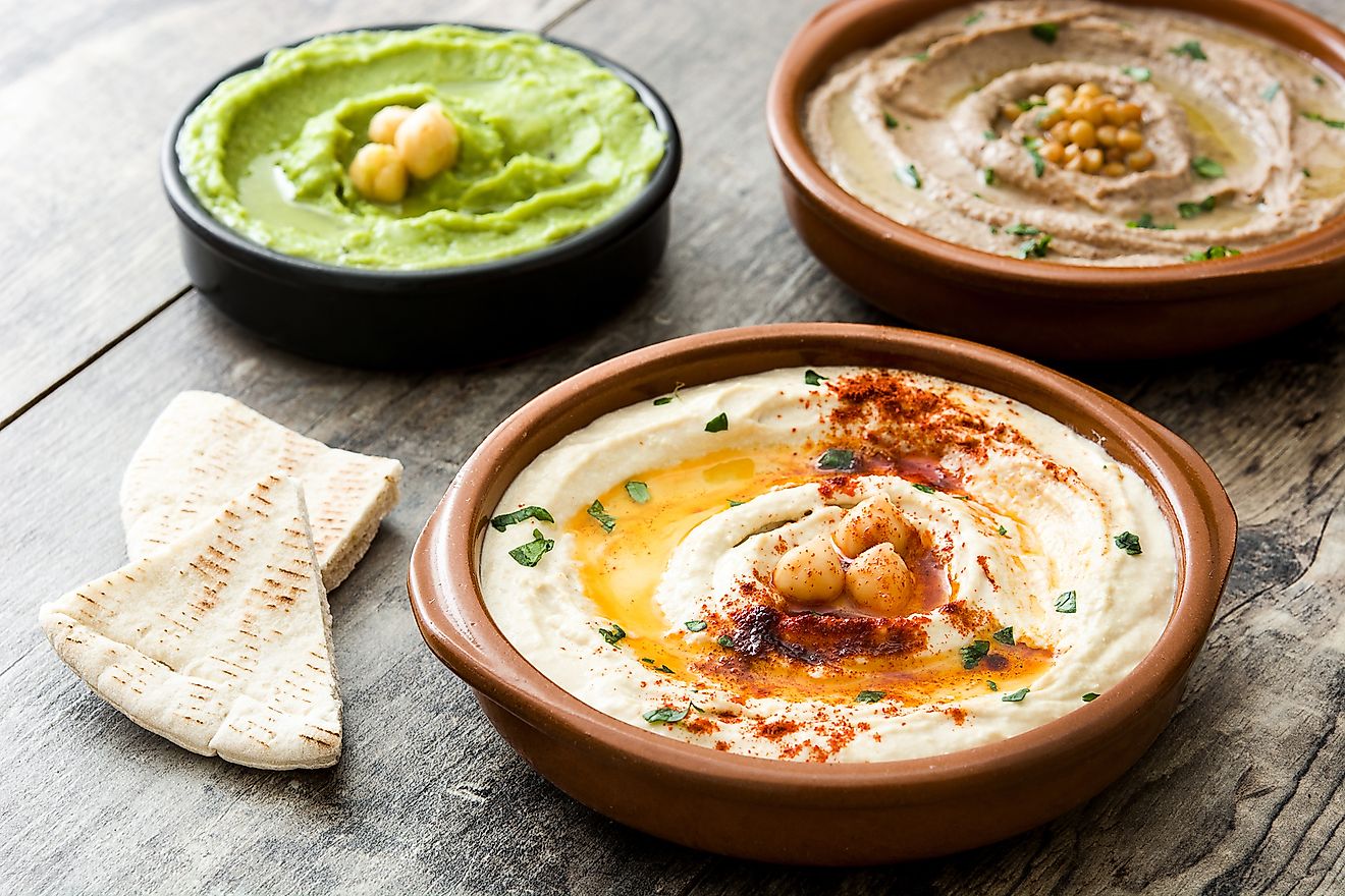 Chickpea hummus, avocado hummus and lentils hummus on wooden table.