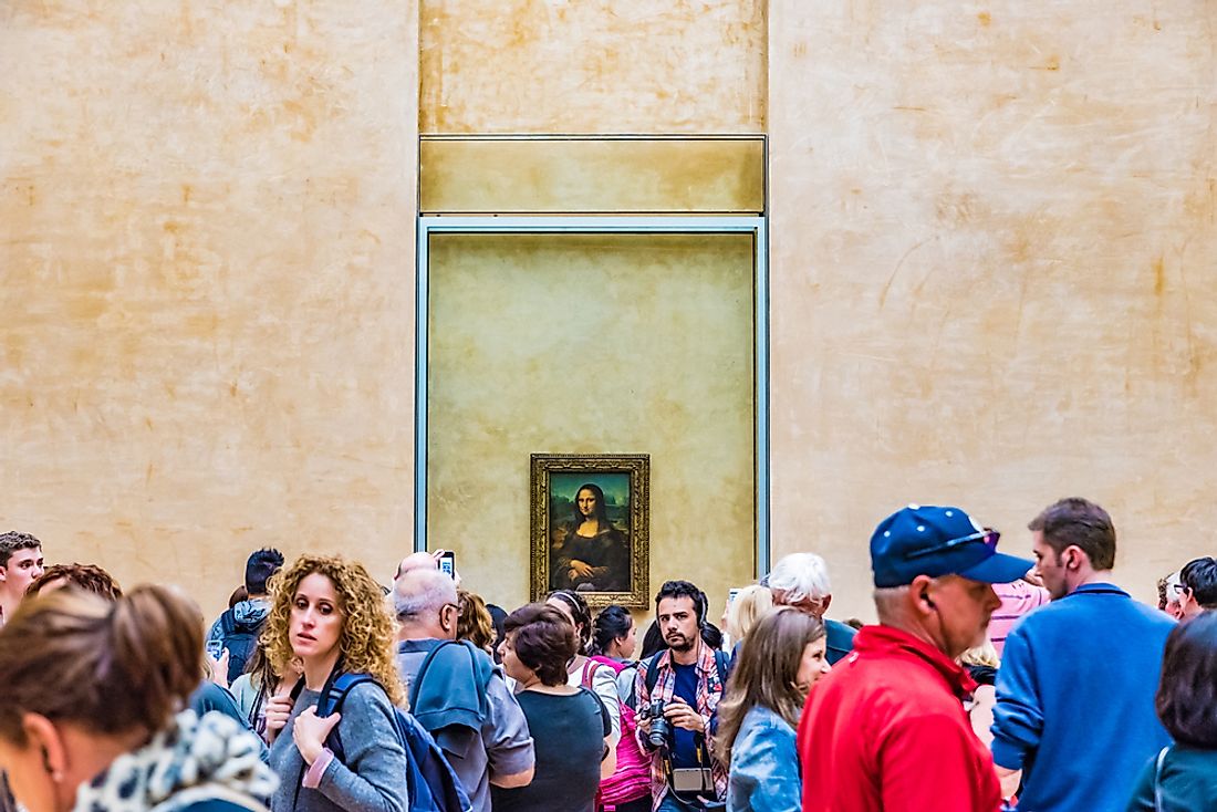 Editorial credit: Takashi Images / Shutterstock.com. The Mona Lisa behind a crowd of museum-goers at the Louvre.