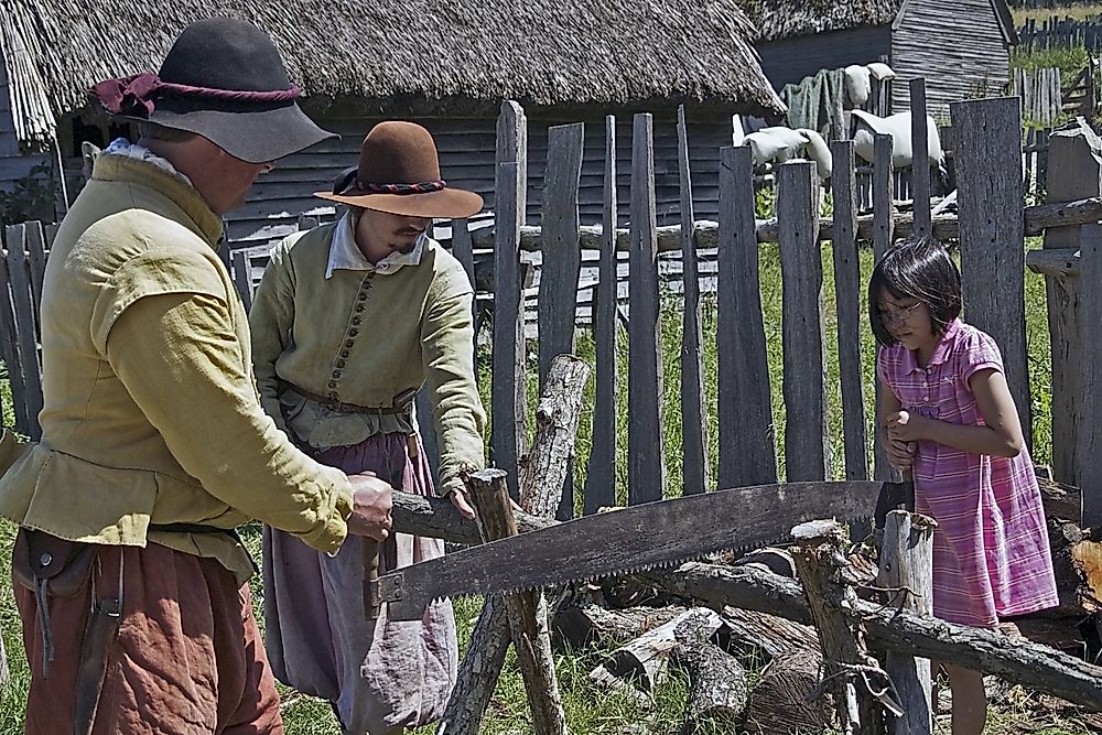 Visitor learning to saw wood at the Plimoth Plantation living museum in in Plymouth, Massachusetts. Editorial credit: Suchan / Shutterstock.com