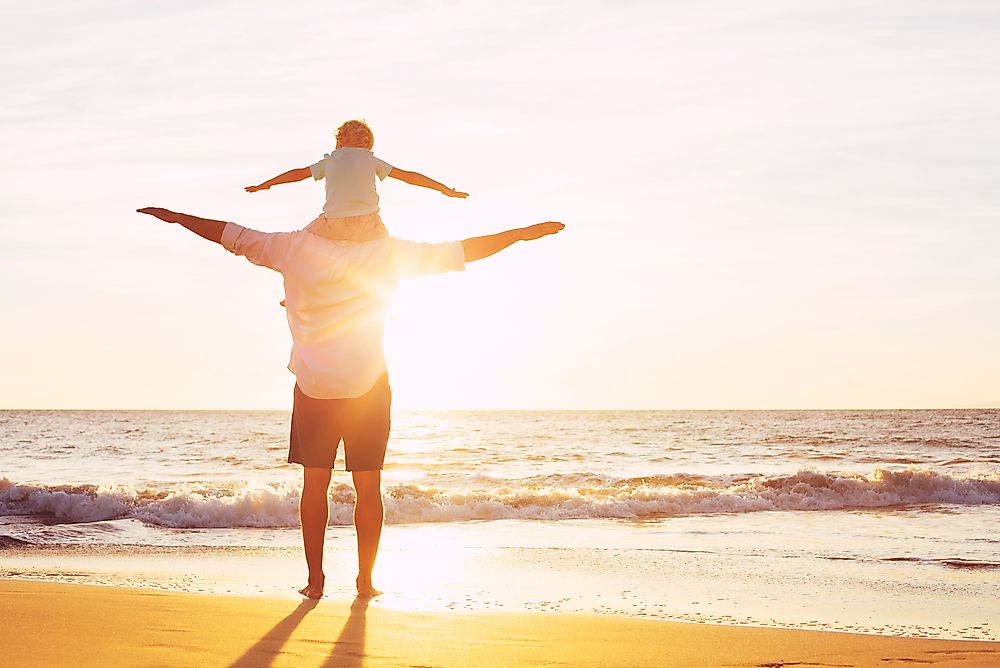 A father and son enjoy time together on the beach. Work-life balance is one indicator of quality of life. 