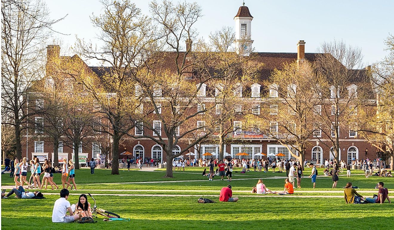 Students walk and sit outside on Quad lawn of University of Illinois college campus in Urbana Champaign