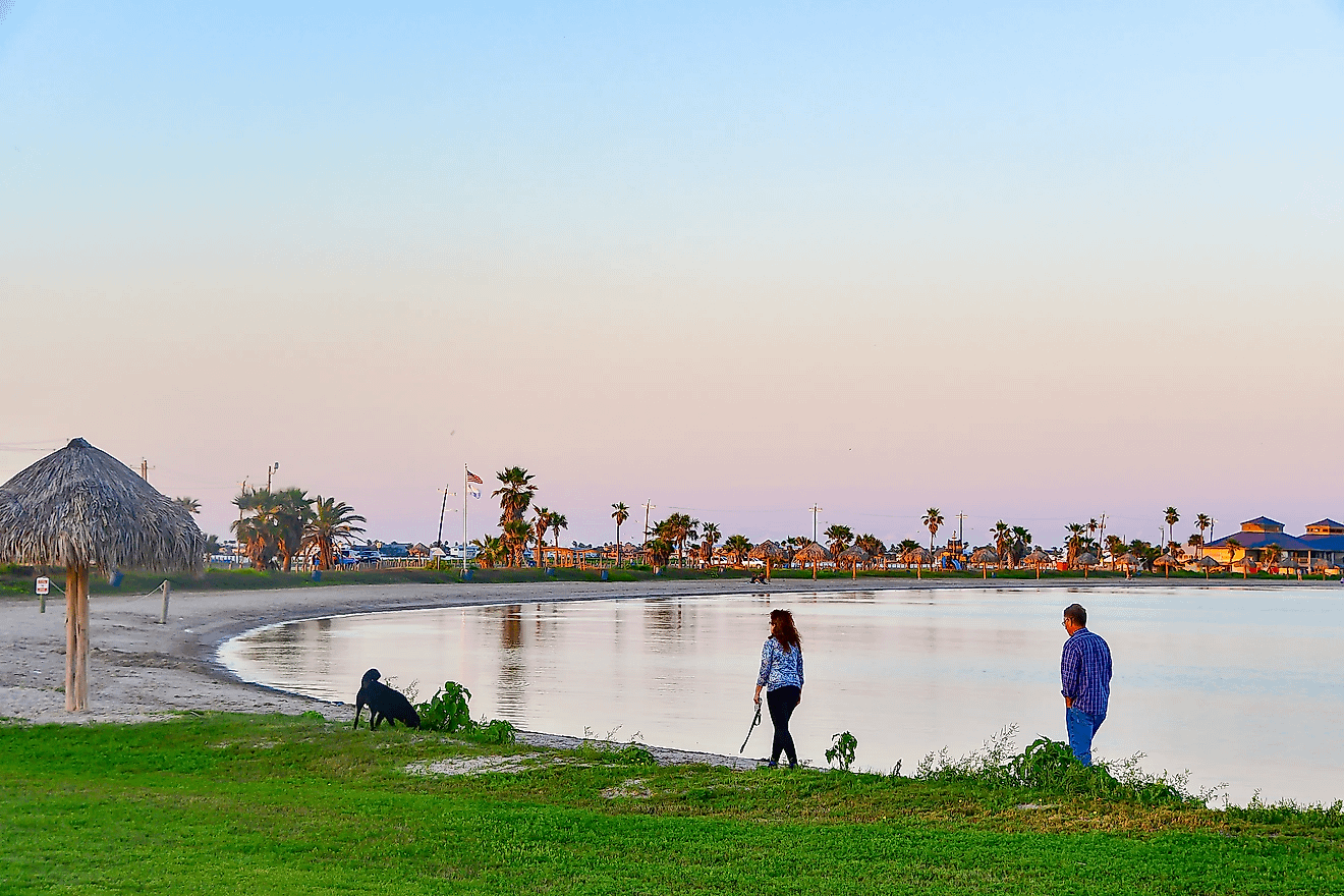 Two people walking along the beach in Rockport, Texas. Image credit Grossinger via Shutterstock.com