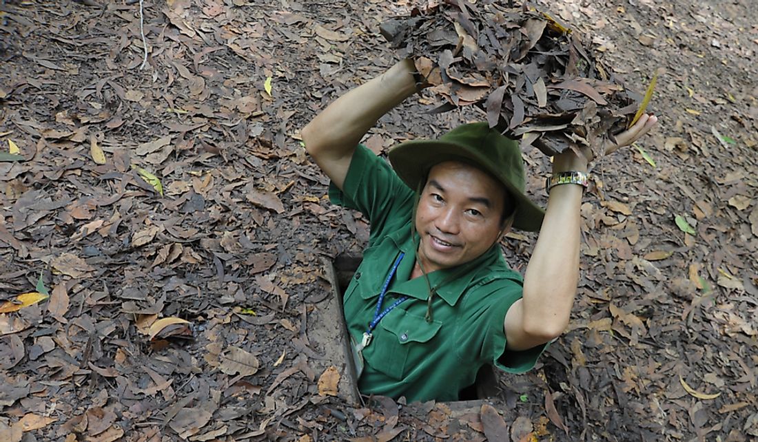 Tour guide demonstrating the Viet Cong's Củ Chi tunnels in Vietnam. Editorial credit: Lano Lan / Shutterstock.com
