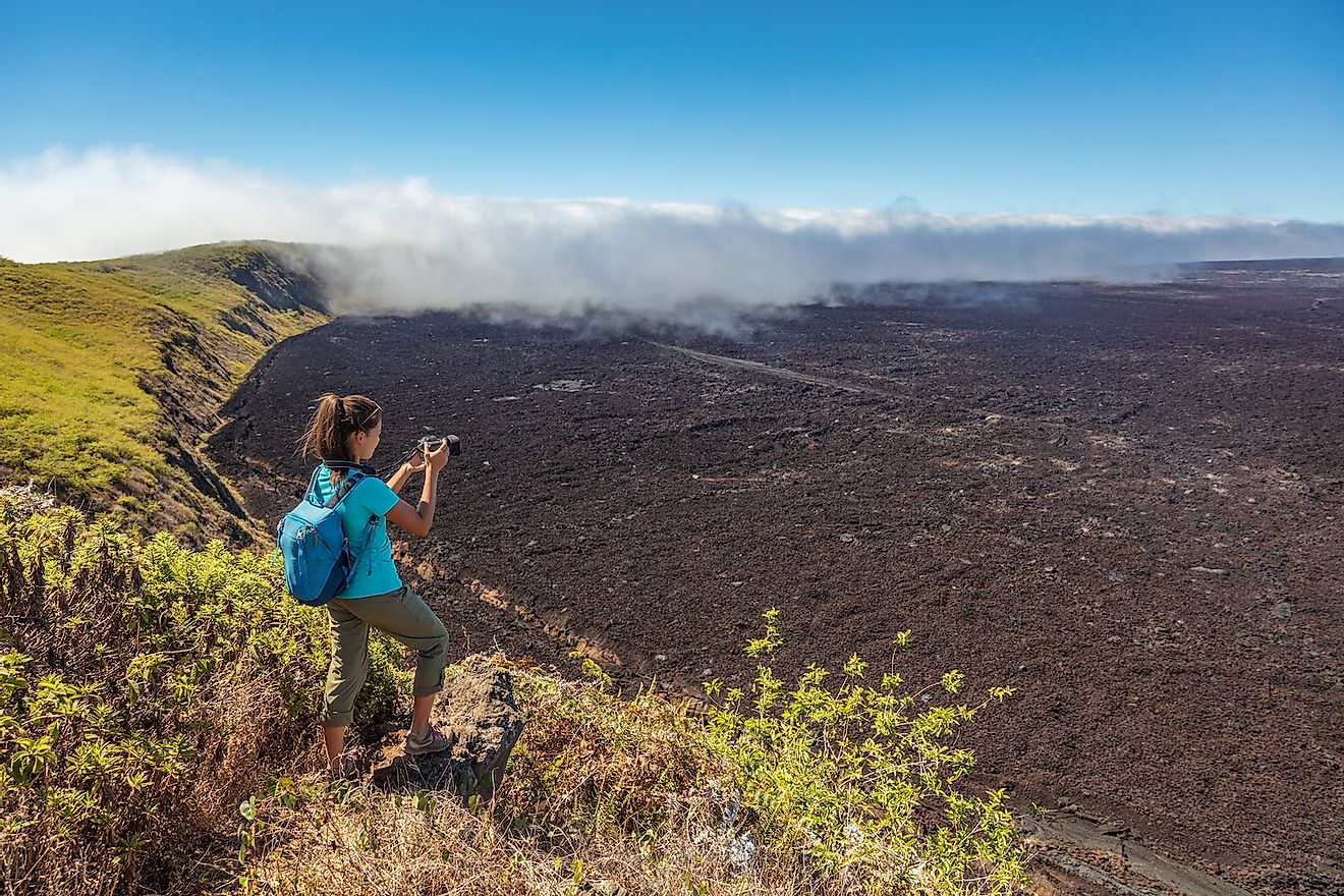 Galapagos tourist hiking on volcano Sierra Negra on Isabela Island. Image credit: Maridav/Shutterstock.com