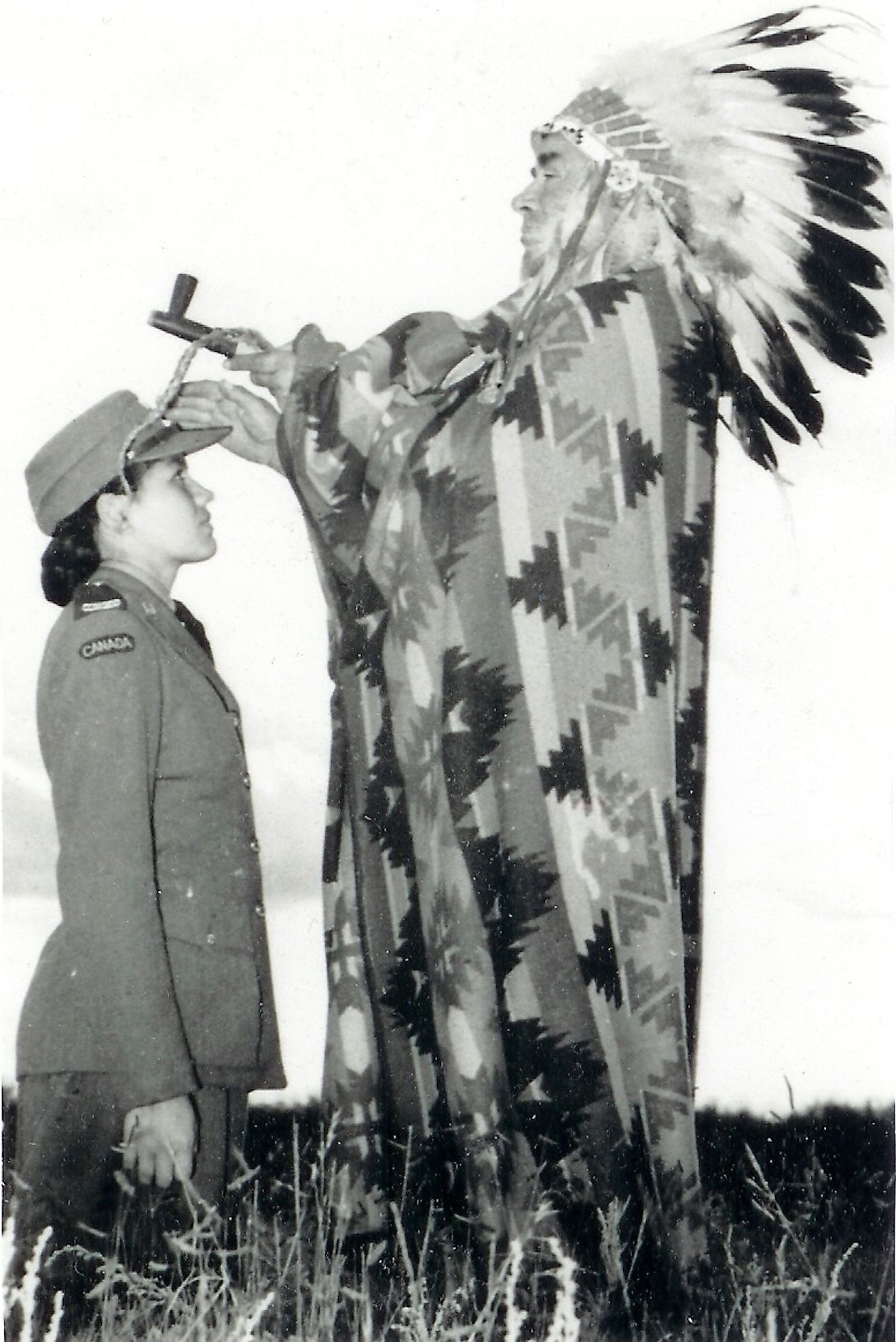 Mary Greyeyes, a Cree from Muskeg Lake Reserve, served in the Canadian Women’s Army Corps in Canada and Britain. In this staged Army publicity photograph, Greyeyes is seen with Harry Ball, a member of the Piapot First Nation dressed in the garb of a Plains Chief. Image credit: Canada. Dept. of National Defence/Library and Archives Canada