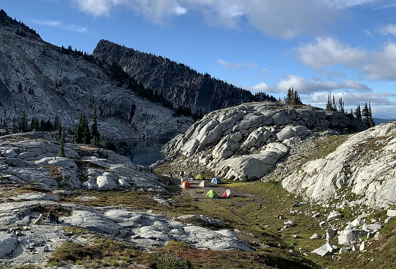 Camping near a rocky outcrop in the Pacific Northwest backpacking, summer hiking, colorful tents.