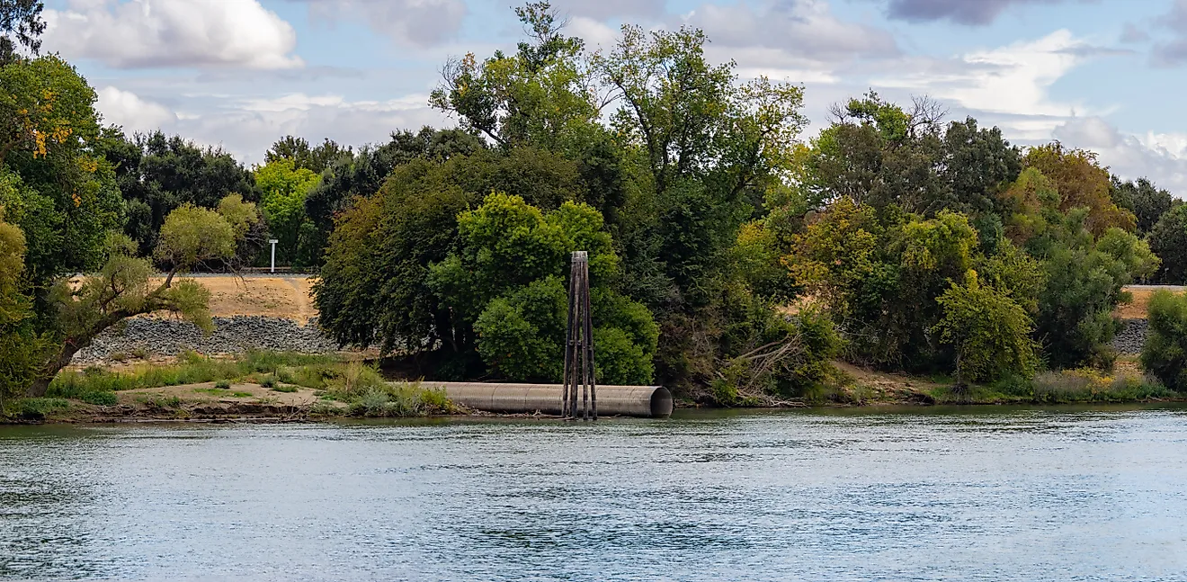 Levee on sacramento river panorama with drainage pipe 