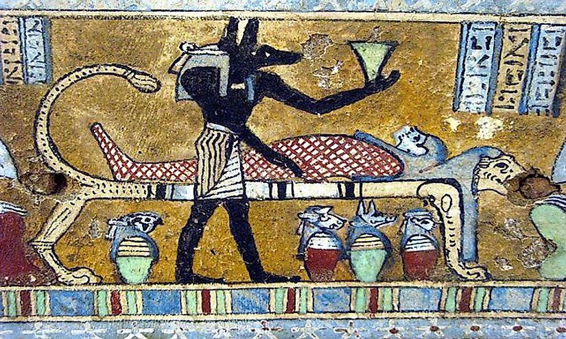 Anubis, the Egyptian God associated with mummification and afterlife is depicted in a painting with the body of the deceased.