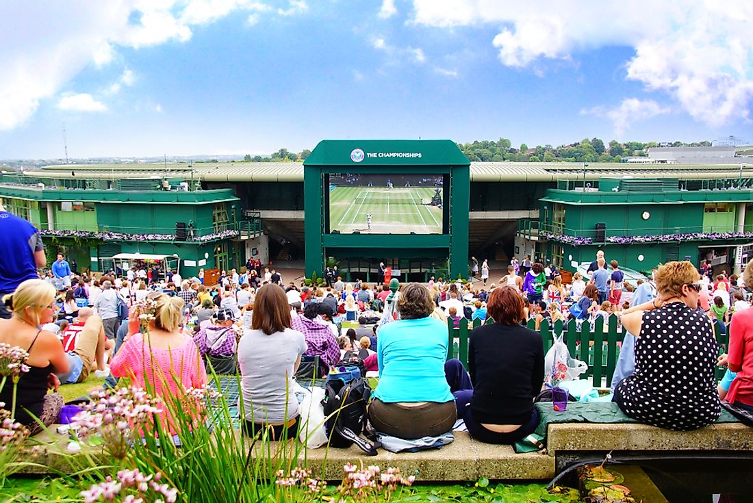 A crowd of people watched Tennis Wimbledon Championship Final round through the screen on the ground around the center court. Credit: Meaning March / Shutterstock.com