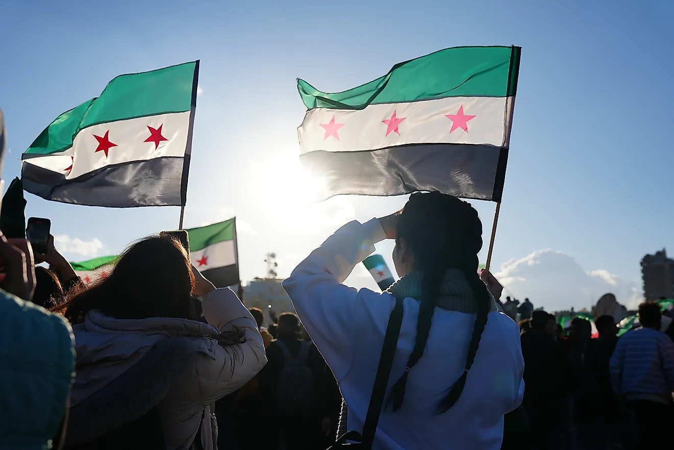 Syrians celebrate the fall of Assad's regime. Editorial credit: Mohammad Bash / Shutterstock.com