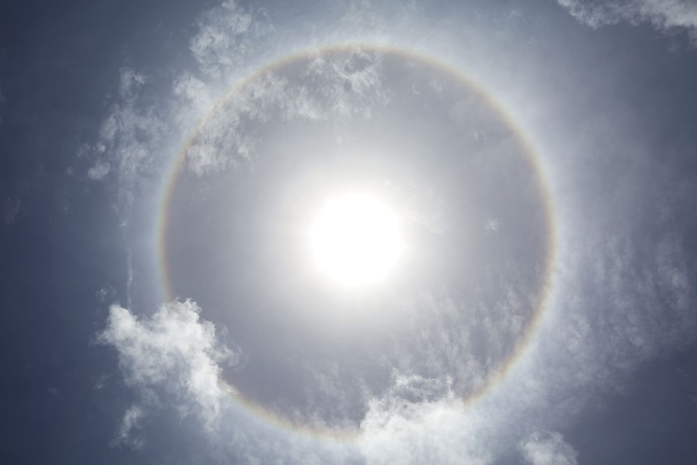 This phenomenon seen in the sky is known as an "ice crystal halo". False sunrises can result from ice crystal halos.