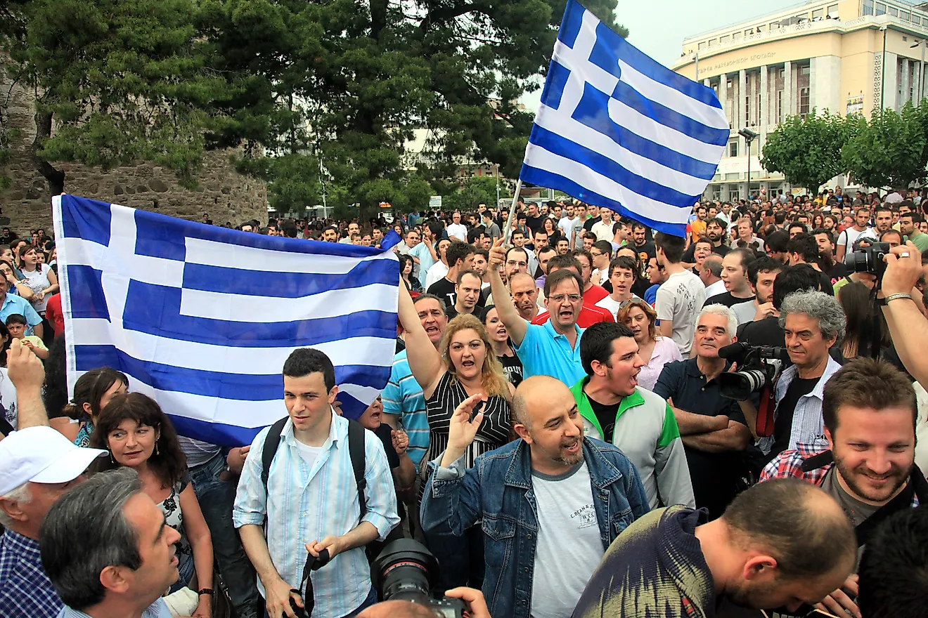 Protesters march on the streets in front of Thessaloniki White Tower, against the economic crisis in Greece. Editorial credit: mavkate / Shutterstock.com.