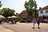Street scene from historic Williamsburg Virginia at Merchants Square with people visible.