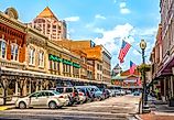 Quaint downtown main street with commercial storefront shops and flag in Roanoke, Virginia, USA.