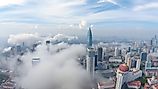 Cityscape of Chongqing at dawn with clouds covering buildings.