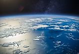 Amazing planet Earth in outer space and the sun's glint beams off the ocean.