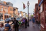 Street view of Annapolis, Maryland, with people walking in the historic town and people dining outdoors. Image credit grandbrothers via Shutterstock