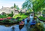 Folks cruising on the canals in Giethoorn, Netherlands. Editorial credit: rob3rt82 / Shutterstock.com