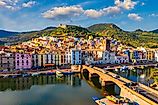 Aerial view of Bosa, Sardinia, with colored houses and a medieval castle.