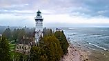 Aerial image of Cana Island Lighthouse in Wisconsin captured on a foggy day along Lake Michigan shoreline. Image by Photo Spirit via Shutterstock. 