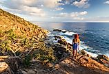 A young woman admires a coastal view at sunrise near Coffs Harbour, Australia.