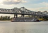 Natchez, Mississippi: Paddle steamer river cruise boat, American Queen, departs under the interstate bridge. Editorial credit: Steve Heap / Shutterstock.com