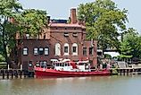 Fire Boat on the River A boat equipped for fire fighting is docked at a brick fire station on the Cuyahoga River in Cleveland, Ohio. 