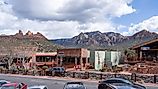 View of buildings in downtown Sedona, Arizona with towering mountains in the backdrop. Editorial credit: Red Lemon / Shutterstock.com
