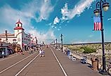 People walking along the famous boardwalk in late afternoon in Ocean City, New Jersey. Image credit: Vlad G via Shutterstock.