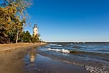 The historic Pelee Island Lighthouse, built in 1833, reflecting on its Lake Erie shoreline.