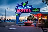 Classic neon sign and vintage Hudson Rambler vehicle at Blue Swallow Motel, a landmark hotel on historic Route 66. Editorial credit: Sandra Foyt / Shutterstock.com