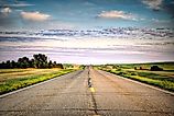 a long country highway rural highway road in North Dakota at sunset with a colorful sky. Editorial credit: adobe stock