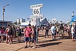 Santa Monica, CA: Crowd of tourists surround the road sign for the end of the famous Route 66 on the Santa Monica Pier in Los Angeles County. Editorial credit: Sandra Foyt / Shutterstock.com