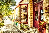 View from the sidewalk, looking at a colorful store adorned with flowers on Main Street in Fredericksburg, Texas, USA, known as "The Magic Mile." Editorial credit: ShengYing Lin / Shutterstock.com