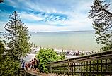 Wooden stairway leading through the forest to the Arch Rock natural limestone formation in Mackinac Island. Image credit: Sanya Kushak via Shutterstock.