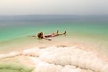 Woman relaxing in salty water of the Dead Sea. Via Shutterstock / xamnesiacx84