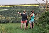 A woman pointing towards the Red Deer river valley, near Lacombe, Alberta. Image credit Carol Provins via Shutterstock