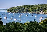 Sailboats and motorboats rest at anchor in Rockport Harbor, Maine, on a beautiful summer day.