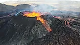 A landscape of lightening erupting from Mauna Loa Volcano in Hawaii with smoke and a hazy sky. 