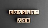 The words "Consent Age" formed from wooden blocks with letters.
