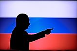 Silhouette of President Vladimir Putin in front of Russian flag.