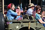 A parade participant recreating the iconic World War II image of Rosie the Riveter during a July 4th parade in Smyrna, Delaware. Editorial credit: The Old Major / Shutterstock.com