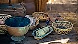 Ancient valuables in various bowls and containers on a wooden table.