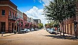 Cars parked along city street in downtown Natchez on a summer day. Editorial credit: VioletSkyAdventures / Shutterstock.com