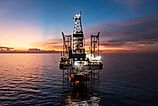 Aerial view of offshore jack up rig and offshore platform during sunset for oil and gas exploration and production.