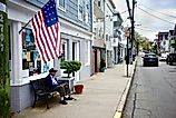 An elderly man seated under an old American flag on Main Street in Stonington, Connecticut. Editorial credit: Joe Tabacca / Shutterstock.com