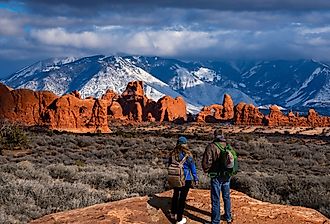 Couple in awe of La Sal Mountains at Arches National Park in Moab, Utah.