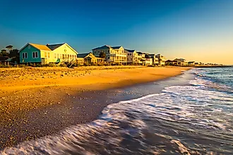 Waves in the Atlantic Ocean with soft morning light illuminating beachfront homes at Edisto Beach, South Carolina.