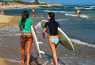 Two surfers on Ditch Plains beach go surfing in the Hamptons in Montauk, New York. Image credit James Kirkikis via Shutterstock